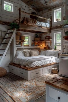 a bed sitting in the middle of a room next to a kitchen and staircases