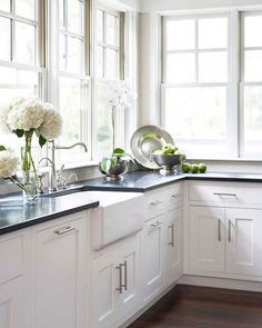 a kitchen with white cupboards and black counter tops is seen on the phone screen