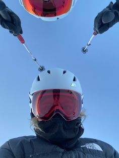 a person wearing skis and goggles looking up at the sky