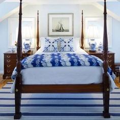 a bedroom with a four poster bed and blue accents on the walls, along with striped rugs