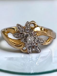 a gold and diamond ring sitting on top of a glass plate