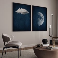 two paintings hang on the wall above a coffee table in a living room with a chair and lamp