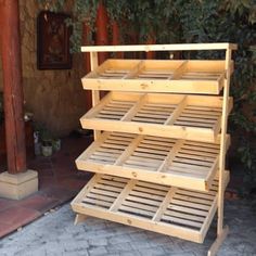 a wooden display case sitting on top of a brick floor next to a tree and building