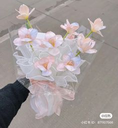 a person holding a bouquet of flowers in their hand on the street with no people around