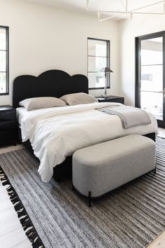 a large bed sitting on top of a rug in a bedroom