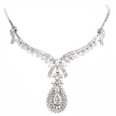 This conspicuous diamond necklace with a detachable pendant is crafted in solid platinum. Depicting romantically designed ribbon 'knots' on both sides, and diamond-studded ribbon ends at the center, this versatile necklace can be worn with or without the pear shape pendant. The latter is set with a combination of marquise and round-faceted diamonds, while the necklace exposes marquise and baguette diamonds. The necklace and the pendant is center with a GIA certified pear-shape diamond approx. 2. Elegant Evening Necklace With Baguette Cut, Platinum Marquise Necklace For Wedding, Elegant Evening Diamond Necklace With Baguette Diamonds, Baguette Cut Diamond Necklace For Evening, Elegant Baguette Cut Necklace For Evening, Classic Wedding Diamond Necklace With Baguette Diamonds, Classic Diamond Necklace With Baguette Diamonds For Wedding, Classic Baguette Diamond Necklace For Wedding, Elegant Evening Necklaces With Baguette Cut