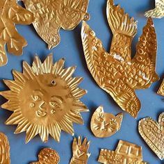 many different types of gold metal items on a blue surface with hearts, cats and birds