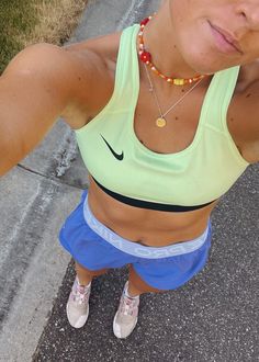 a woman is taking a selfie with her cell phone while wearing shorts and a sports bra top