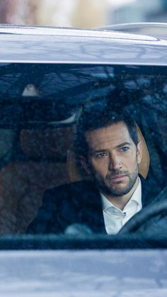 a man in a suit and tie sitting in a car