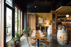 a restaurant with wooden tables and chairs in front of large glass doors that look out onto the outside