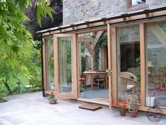 a patio area with glass walls and wooden furniture