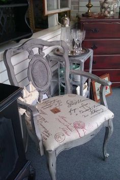 a chair with writing on it sitting next to a dresser