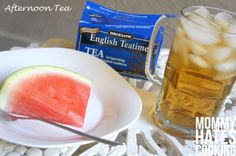 watermelon and ice tea on a white plate next to a cup of tea