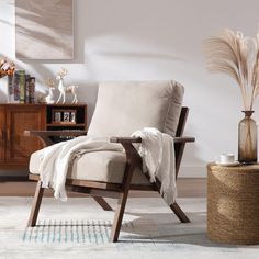 a chair with a blanket on it in a living room next to a coffee table