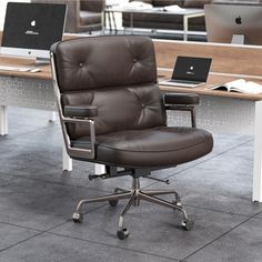 an office chair sitting in front of a desk with two laptops on top of it