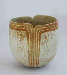 a brown and white vase sitting on top of a table