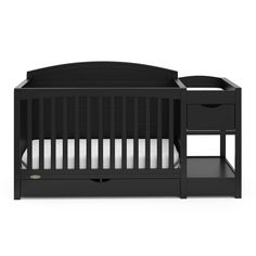 a black crib with two drawers and a white sheet on the bottom half of it