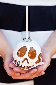 a person holding a cake shaped like a skull