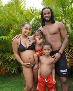 a man and two women standing next to each other in bikinis