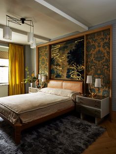 a bedroom with a bed, nightstands and paintings on the wall