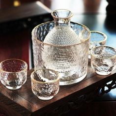 a glass pitcher and four glasses on a wooden tray