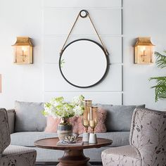 a living room with couches, chairs and a table in front of a mirror