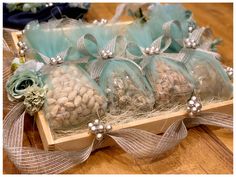 several bags filled with nuts sitting on top of a wooden table next to ribbons and flowers