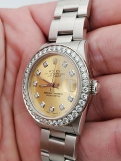 Women's Midsize Rolex DateJust 31mm Stainless Steel Watch with Champagne Diamond Dial and Diamond Bezel. Pre-Owned SN# Y52**** Brand: Rolex. Bezel: Diamond. Gender: Women's. Dial: Diamond Dial. Condition: Excellent. Dial Color: Champagne. Movement: Self-Winding. Case Dimensions: 31mm. Metal Type: Stainless Steel. Bracelet / Strap: Stainless Steel. Box / Certificate: Rolex Box / Certificate of Authenticity. Service Warranty: One (1) Year Limited Service Warranty. Anniversary Diamond Watch With Date Indicator, Elegant Anniversary Jewelry And Watches With Date Display, Elegant Diamond Watch With Date Display For Anniversary, Round Diamond Watch Accessories For Anniversary, Anniversary White Gold Diamond Watch With Date Display, Diamond Watch With Date Display For Gift, Classic Round Diamond Watch With Date Display, Luxury Round Diamond Watch With Date Display, White Gold Watch Accessories For Anniversary