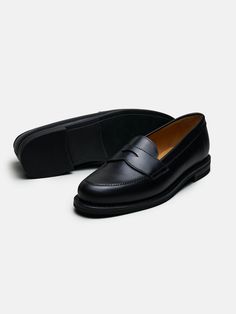 The Ivy Loafer is a penny loafer inspired by old-school Ivy style. It is constructed with a slightly boxier and more relaxed look than our flagship penny loafer model, resulting in a timeless and sporty silhouette. The shorter vamp and the 360-degree welt further reinforce the design cues that draw inspiration from collegiate aesthetics.    Fits large in size  We recommend selecting half a size down from what you usually wear in lace-up shoes. Please refer to our Size Guide above or reach out to Classic Goodyear Welted Wingtip Tassel Loafers, Classic Wingtip Loafers With Rubber Sole, Classic Tassel Loafers With Goodyear Welt For Work, Classic Plain Toe Tassel Loafers, Classic Goodyear Welted Tassel Loafers, Classic Brogue Moccasins For Derby, Classic Black Loafers With Goodyear Welt Construction, Sleek Black Slip-on Loafers, Morjas Penny Loafer