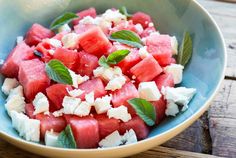 watermelon, feta and mint salad in a bowl on a wooden table