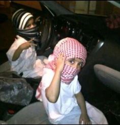 two young children sitting in the back of a car with their heads coverings up