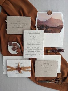 the wedding stationery is laid out on top of each other, along with two pairs of scissors