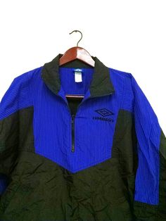 Rad 1990s UMBRO windbreaker jacket-- lightweight pullover jacket with adjustable toggle waistband. This jacket is purple and black the pictures appear to be more blue than purple with lighting. This item is in excellent vintage condition. * Size: Small * Shell: 100% Nylon * Insert: 70% nylon 30% polyester * Machine washable * By: UMBRO Vintage Black Windbreaker For Outdoor Activities, 90s Windbreaker For Outdoor Activities, 90s Style Windbreaker For Outdoor Activities, 90s Style Long Sleeve Windbreaker For Outdoor Activities, 90s Style Long Sleeve Track Jacket For Outdoor, 90s Style Black Track Jacket For Outdoor, 90s Style Nylon Windbreaker For Streetwear, 90s Black Windbreaker For Outdoor Activities, 90s Style Black Windbreaker For Outdoor Activities