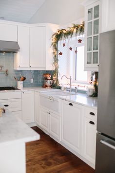 the kitchen is decorated for christmas with garland on the door and lights hanging from the ceiling