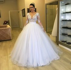 a woman in a white wedding dress standing in front of a mirror