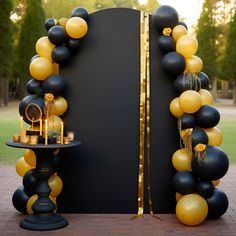 a black and gold party arch with balloons