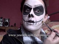 a woman with makeup painted to look like jack - o'- lanterns is holding a brush