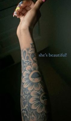 a woman's arm with flowers on it and the words she's beautiful