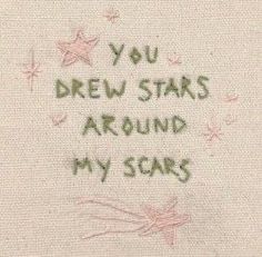 a close up of a piece of cloth with writing on it that says, you drew stars around my scars