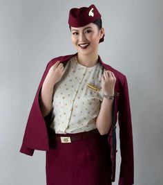 a woman in an airplane uniform poses for the camera with her hand on her hip