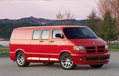 a red van parked in front of a lake