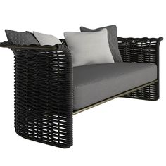 a black wicker chair with two pillows on the back and one pillow in front