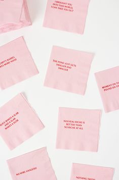 pink napkins with words on them sitting on top of a white countertop next to each other