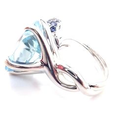 Chanel Camellia Flower 18k White Gold Aquamarine Sapphire Ring       Metal: 18k white gold  Size: European 48 US 4.5  Weight: 13.8 grams  Width: 16mm  Stones: One round large aquamarine 15mm 35 round blue sapphires  Hallmarks: CHANEL 750 48 17L523  Dimensions reference the ring size and are not specific to the ring itself. Luxury Light Blue Round Ring, Luxury Light Blue Round Rings, Luxury White Gold Aquamarine Ring, Luxury White Gold Ring With Aquamarine, Luxury Blue Topaz Ring In 14k White Gold, Elegant Blue Topaz Ring With Polished Finish, Chanel Camellia Flower, Chanel Camellia, Camellia Flower