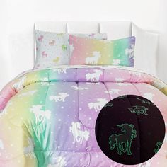 a bed with unicorns and stars on the comforter is shown in front of a white wall