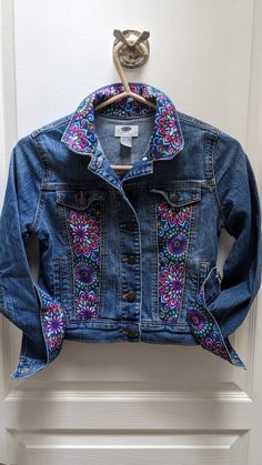 a blue jean jacket hanging on a white door