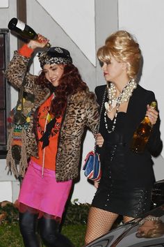 two women dressed in costumes and holding bottles