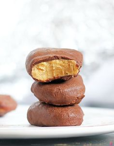 three chocolate donuts stacked on top of each other with peanut butter in the middle