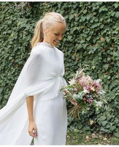 a woman in a white dress holding a bouquet