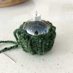 a green ornament sitting on top of a table next to a pair of scissors